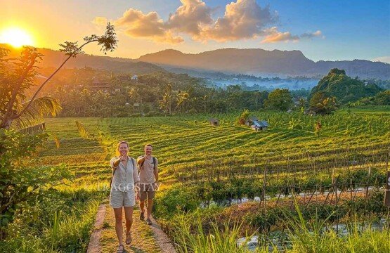 Two happy travelers posing after finishing their scenic trekking journey through the Sidemen Rice Terrace.