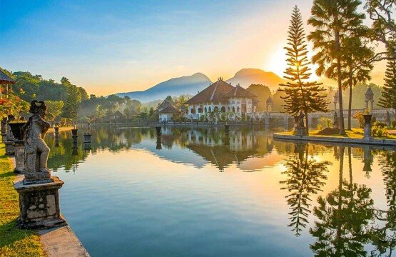 A large serene pond reflecting the morning sky at Taman Ujung Water Palace Sukasada.