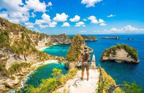 A man standing on the cliff edge looking out at the magnificent rock formations of Thousand Islands Viewpoint.