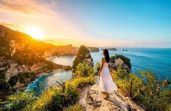 A woman standing at the viewpoint watching a golden sunrise over the ocean at Thousand Islands.