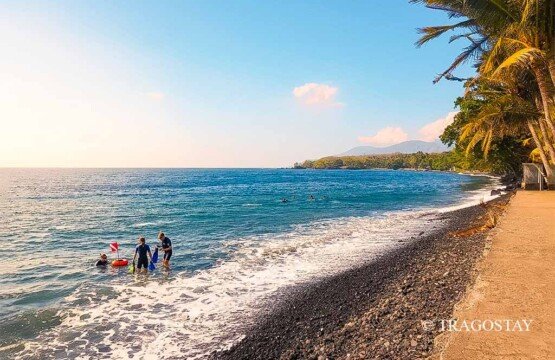 A group of scuba divers starting their shore entry dive at Tulamben Beach in the morning.