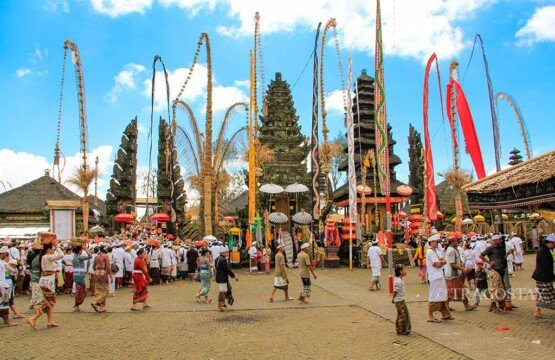 Balinese Hindus in traditional attire crowding the middle courtyard of Ulun Danu Batur Temple to enter the main sanctuary.