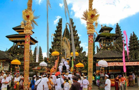 Balinese Hindu devotees walking through the outer entrance gate of the Ulun Danu Batur Temple complex.