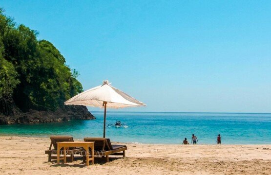 A relaxing sunbed and beach umbrella setup on the soft white sand of Virgin Beach.