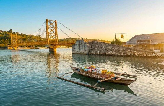 A local fishing boat carrying groceries and supplies anchored in the shallow water near Yellow Bridge.